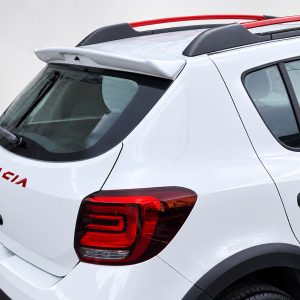 Rear view of a white Dacia SUV with a spoiler, roof rails, and red taillights.
