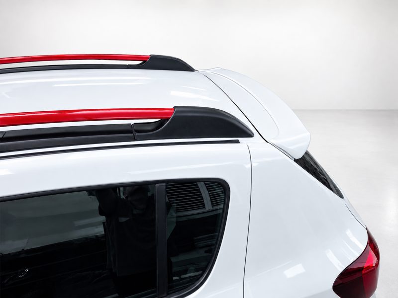 A-445_4jpg - OPSHOLDERS Close-up of the top rear section of a white car with red roof rails and black roof rack mounts.