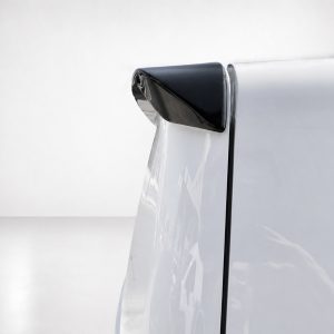 Close-up of a silver car door with a small black curved spoiler at the window edge.