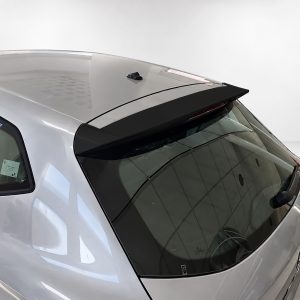 Rear view of a silver hatchback with a black roof spoiler and shark-fin antenna, seen from above.