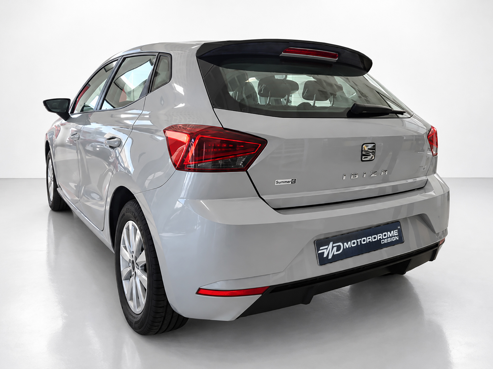 A-451_2jpg - OPSHOLDERS Silver SEAT Ibiza hatchback from a rear three-quarter angle, showing taillights and rear badge in a studio setting.