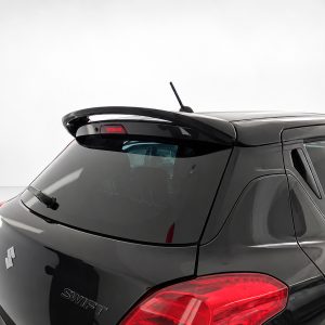 Rear view of a dark Suzuki Swift hatchback with a roof spoiler and rear windshield wiper, shown in a studio setting.