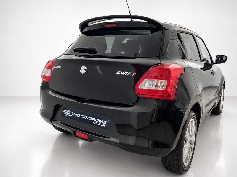 Rear view of a black Suzuki Swift in a studio, showing tail lights and MD MotorDrome Design plate on the bumper.
