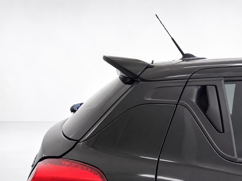 Black SUV rear with a roof spoiler, antenna, and red taillights visible on a light backdrop
