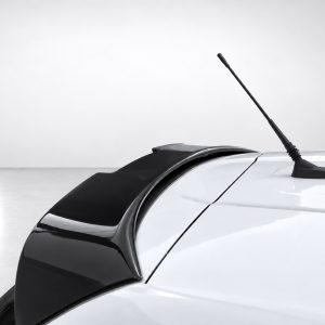 White car roof with a black whip antenna extending upward, seen from the rear side edge in a bright studio setting.