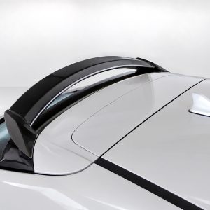 Close-up of a white sports car roof showing a black Targa-style bar and a shark-fin antenna on top.