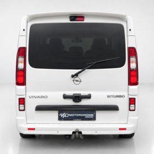 A-455_2jpg - OPSHOLDERS Rear view of a white Opel Vivaro van with 'VIVARO' and 'BITURBO' badges, rear window wiper, and tow hitch