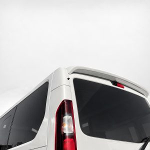 A-455_5jpg - OPSHOLDERS Rear corner of a white van with dark rear windows and vertical red taillights against a pale sky.
