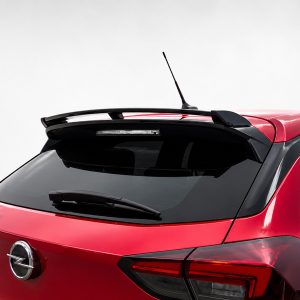 Red hatchback rear end with a spoiler and roof antenna, showing the Opel/Corsa badge on the trunk lid