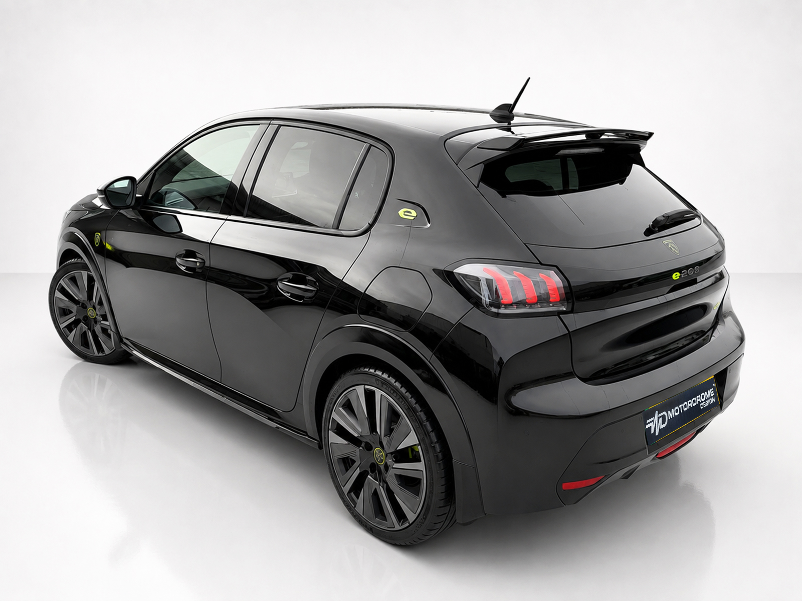 A-456_2-1jpg - OPSHOLDERS Black electric hatchback shown from a rear-left three-quarter angle, highlighting glossy finish, LED tail lights, and large alloy wheels against a white studio backdrop.
