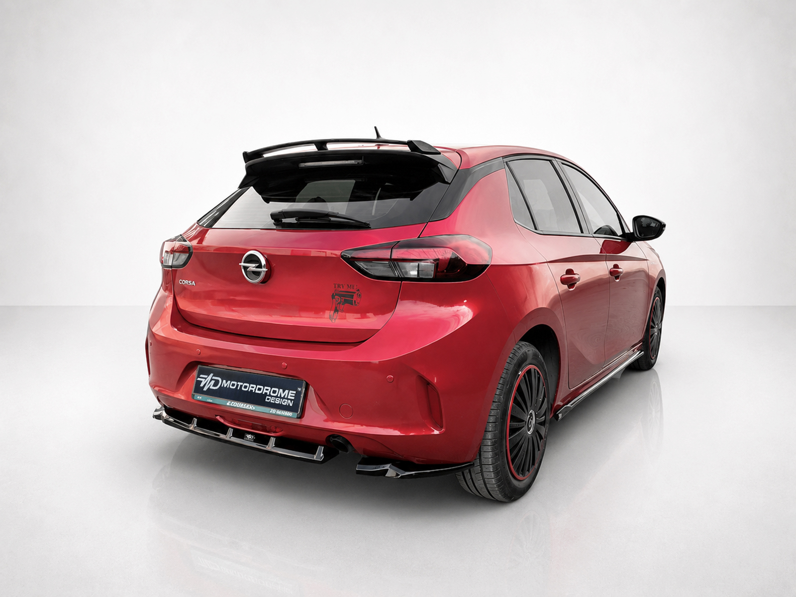 A-456_2jpg - OPSHOLDERS Red Opel Corsa hatchback seen from the rear-left side with a sport rear diffuser and black spoiler, displaying a showroom-like backdrop and a custom 'Motordrome Design' plate.