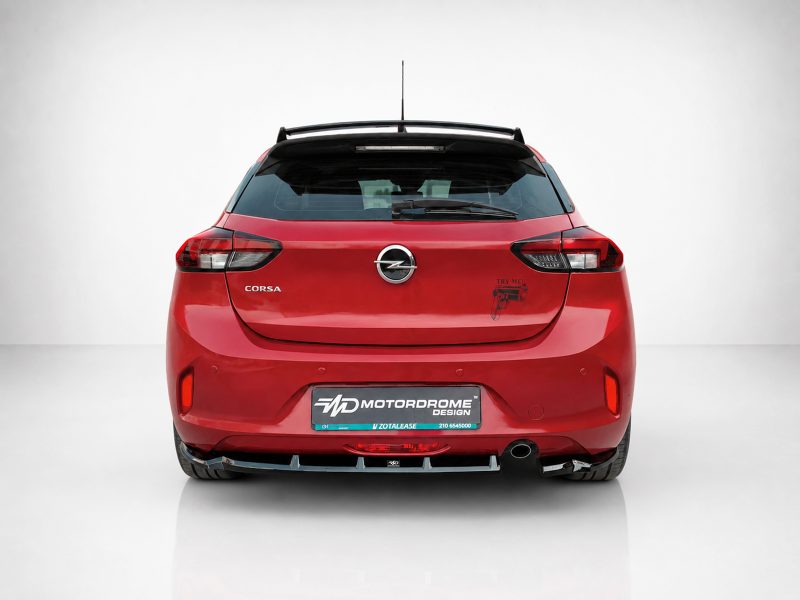 A-456_3jpg - OPSHOLDERS Rear view of a red Opel Corsa hatchback in a studio setting, with a Motordrome Design plate and a small decal on the right rear door.