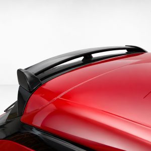 A-456_4jpg - OPSHOLDERS Close-up of a red car roof showing a black rear spoiler and antenna against a light background.