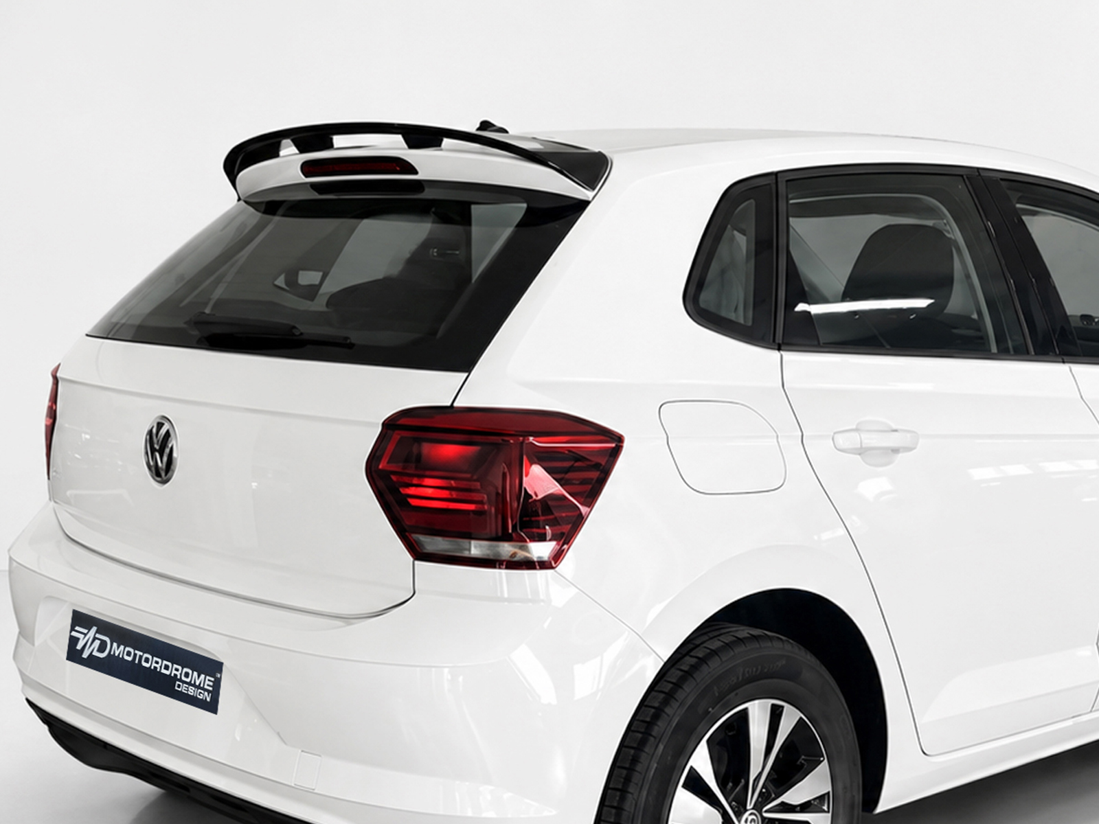 A-457_1jpg - OPSHOLDERS Rear three-quarter view of a white Volkswagen SUV with a roof spoiler, visible tail light, and alloy wheels on display.