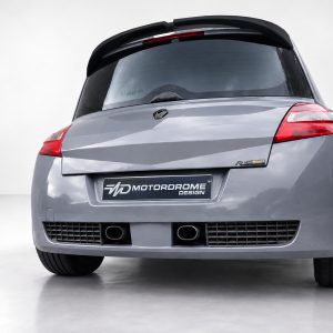 A-459_2jpg - OPSHOLDERS Rear view of a gray hatchback with a Motordrome Design plate and red taillights on the back window