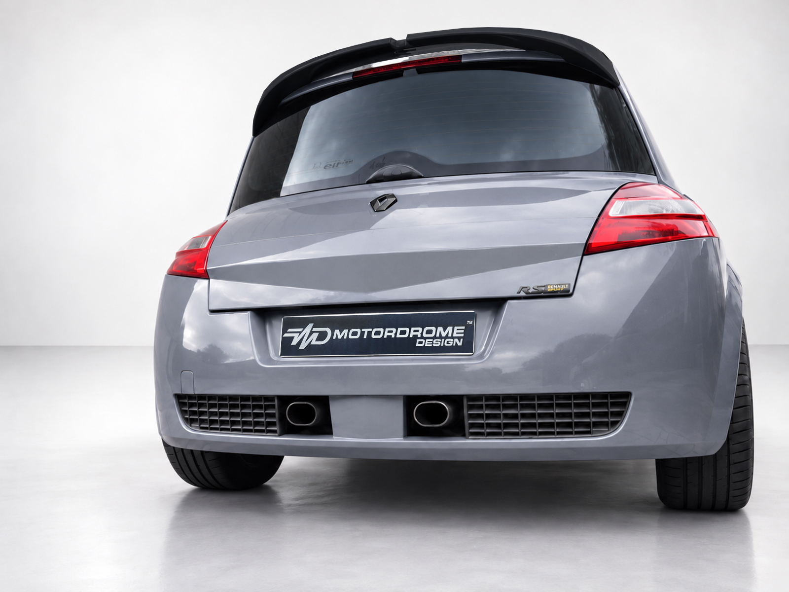 A-459_2jpg - OPSHOLDERS Rear view of a gray hatchback with a Motordrome Design plate and red taillights on the back window