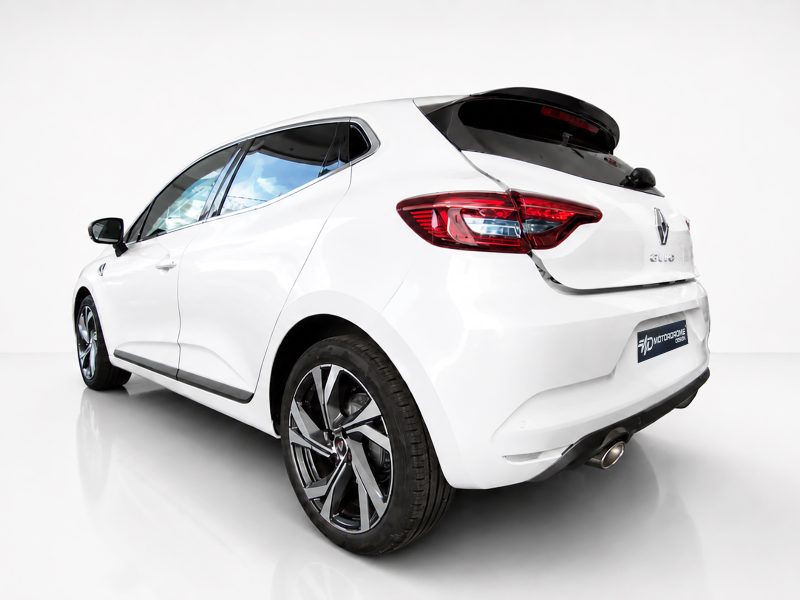 A-460_2jpg - OPSHOLDERS Rear three-quarter view of a white hatchback car in a studio setting, highlighting its taillights and alloy wheels with a glossy floor.