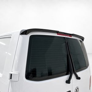 White van rear with two windshield wipers resting on the rear window and a black roof spoiler against a light backdrop