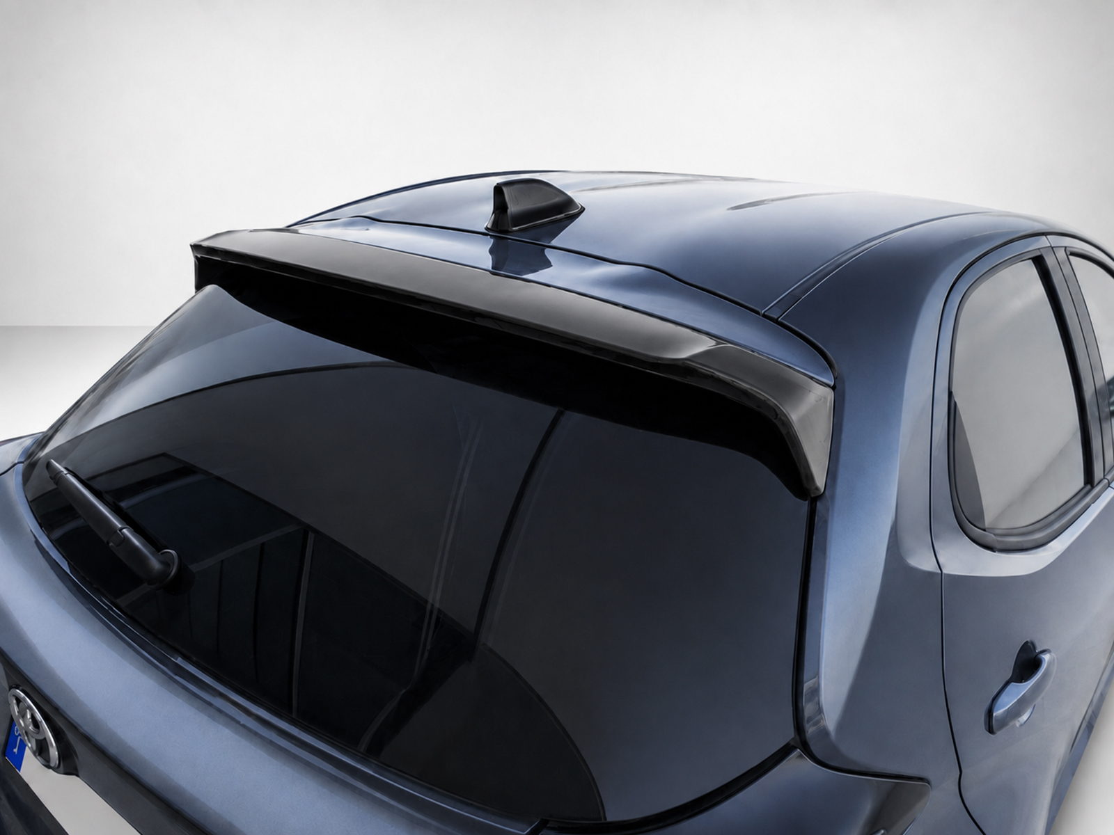 A-463_1jpg - OPSHOLDERS Blue hatchback viewed from above, highlighting a rear spoiler mounted on the trunk and a shark-fin antenna on the roof.