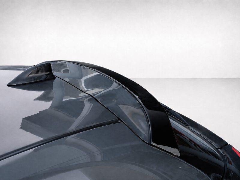 A-463_3jpg - OPSHOLDERS Close-up of a dark glossy sports car hood and cockpit with curved windshield reflections.