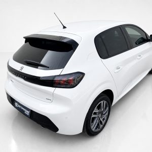 A-465_2jpg - OPSHOLDERS White Peugeot hatchback photographed from the rear-right, showing taillights, rear window, and alloy wheels in a studio setting.