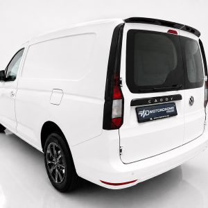 Rear three-quarter view of a white VW Caddy cargo van in a bright studio setting