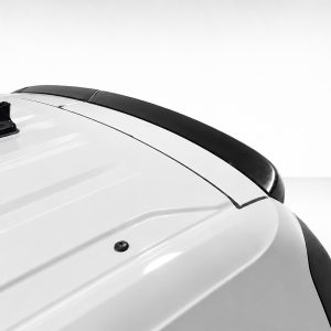 Close-up of a white car roof featuring a black shark-fin antenna and a dark center stripe along the roof.