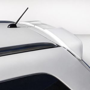 Close-up of a silver car roof showing a black antenna and rear spoiler on a white background.