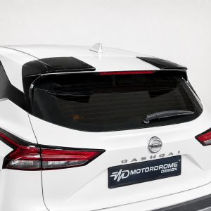 White Nissan SUV rear view with black roof spoiler, tinted rear window, and red taillights; Nissan badge visible above the Motordrome Design plate.