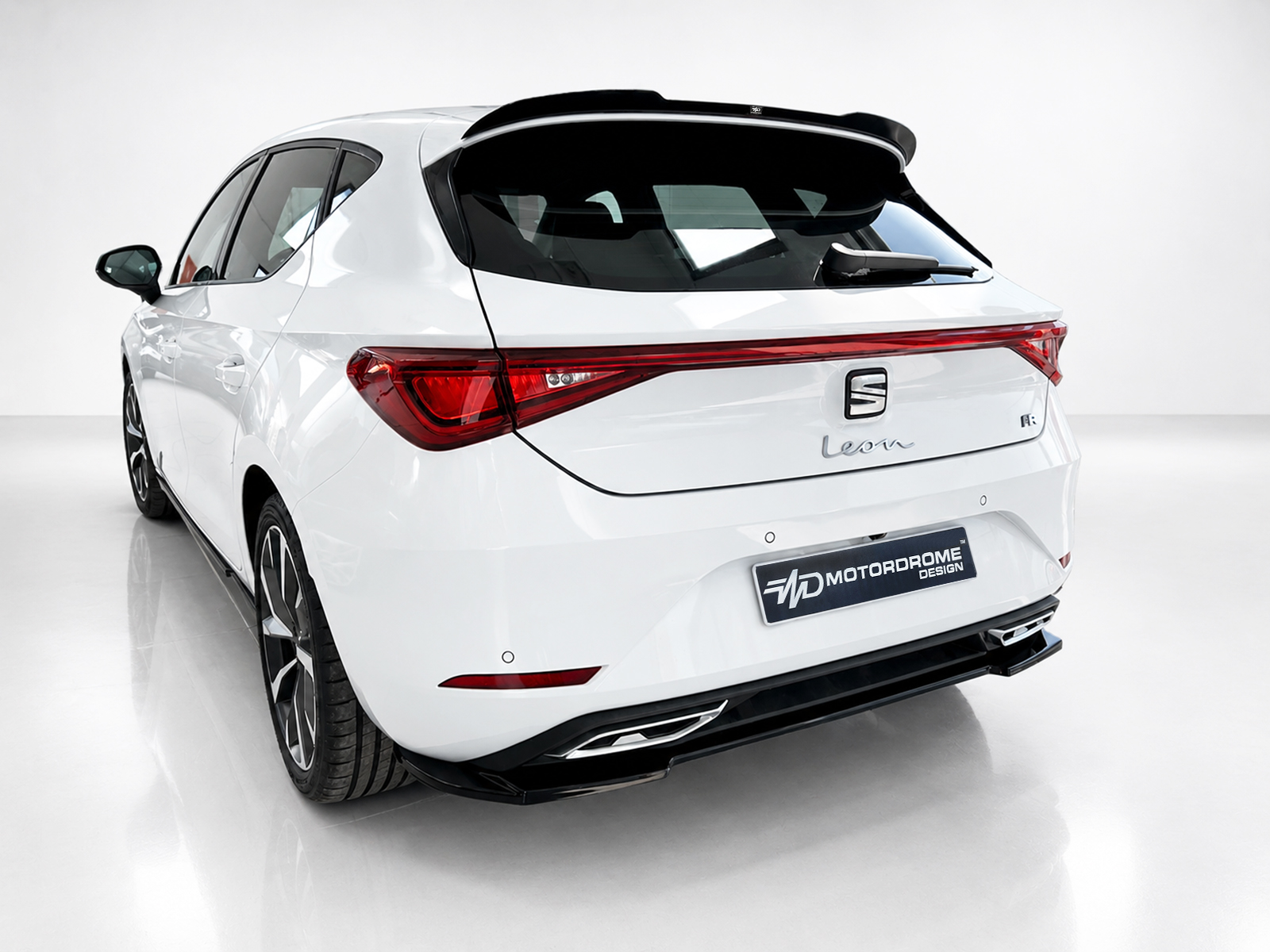 A-475_2jpg - OPSHOLDERS White hatchback viewed from the rear in a studio, showing sleek taillights and a Sporty roof spoiler.