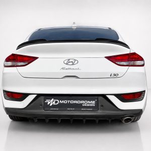 A-477_3jpg - OPSHOLDERS Rear view of a white Hyundai i30 with visible emblem and 'i30' badge, plus a black Motordrome Design plate in a studio setting