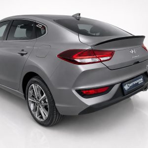 Rear three-quarter view of a gray Hyundai i30 Fastback in a studio setting.