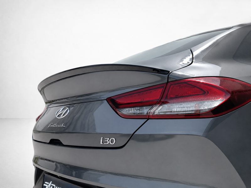 Rear view of a metallic gray Hyundai i30 Fastback, showing the taillight, trunklid, and badge.