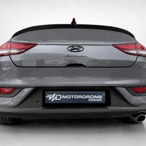 Rear view of a gray Hyundai fastback car with a Motordrome Design license plate plate on the bumper.