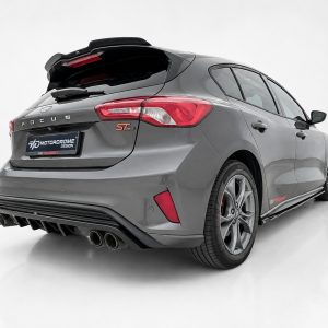 A-479_2jpg - OPSHOLDERS Rear three-quarter view of a gray Ford Focus ST in a studio setting, showing quad exhausts and sporty rear diffuser.