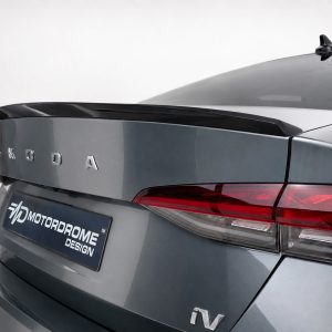 Rear view of a gray Skoda sedan with a chrome badge spelling SKODA and red tail lights; license plate reads 'Motordome Design'