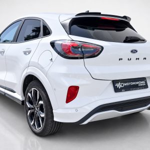 A-481_2jpg - OPSHOLDERS White Ford Puma SUV rear view with taillights and sporty bumper, on a light showroom floor.