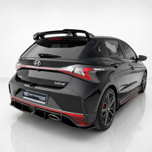 Rear three-quarter view of a black Hyundai i20N hatchback with a rear spoiler and red accents in a studio setting, highlighting its sporty design.