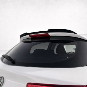 Rear view of a white car showing a rooftop spoiler and rear wiper on the back window, Alfa Romeo badge visible at the lower left.