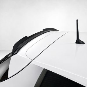 A-485_3jpg - OPSHOLDERS Close-up of a white car roof featuring a black shark-fin antenna and rear window area, viewed from the side.
