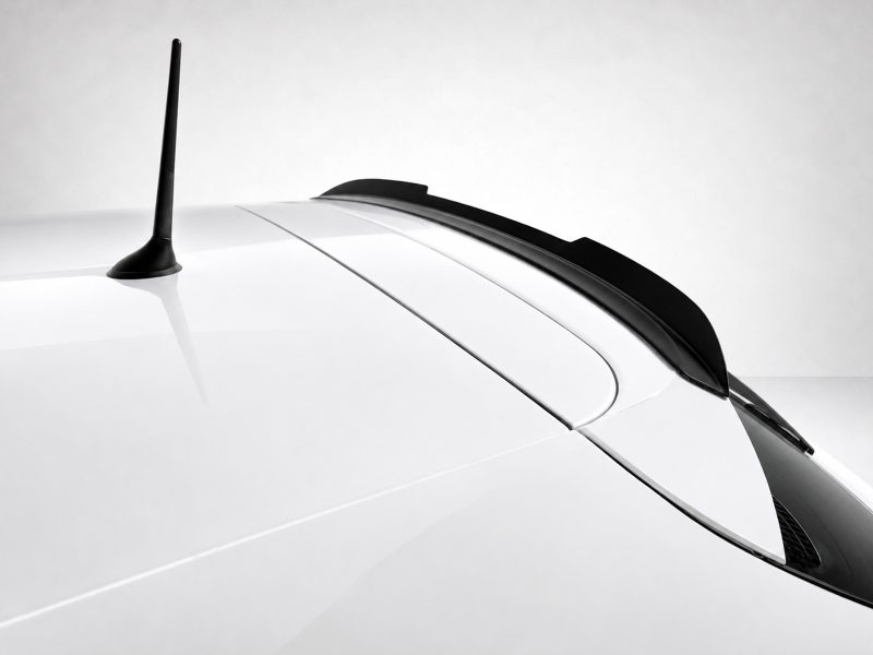 A-485_4jpg - OPSHOLDERS Close-up of a white car roof with a black vertical antenna and rear spoiler/spoiler rail along the rear edge.
