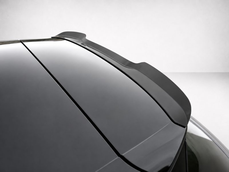 A-487_4jpg - OPSHOLDERS Close-up of a sleek spoiler on a glossy black car's rear edge