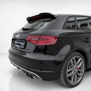 A-487_5jpg - OPSHOLDERS Black Audi sedan shown from a rear three-quarter angle in a bright studio setting, highlighting its taillights and glossy finish.