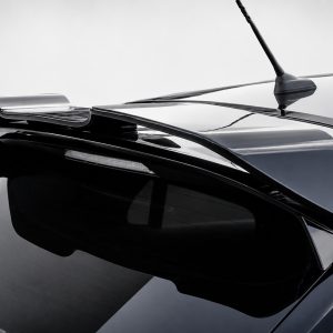 Close-up of a black car rear with a sleek spoiler and antenna against a light background, glossy finish.