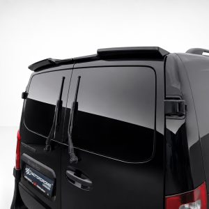 Rear view of a black van with two vertical rear wipers, tinted windows, and a roof rack on a light backdrop.