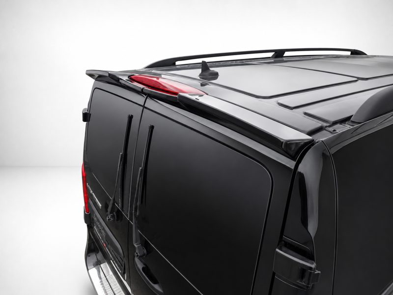 Close-up of the back corner of a black SUV, showing roof rails, rear brake light, and wiper blades.