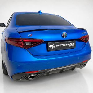 Blue Alfa Romeo sedan viewed from the rear in a bright studio setting, with a black MotorDrome Design plate.