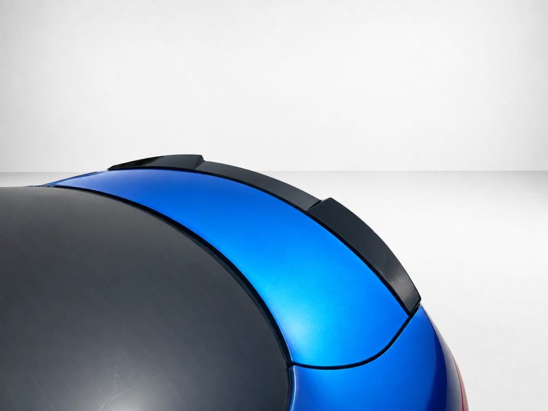 Close-up of a glossy blue and black curved surface against a pale gray background, likely a helmet or vehicle part.