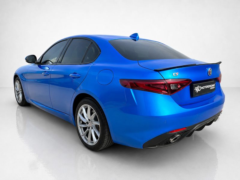 Blue Alfa Romeo sedan shown from rear three-quarter view in a studio setting with a glossy finish.