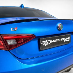 Rear view of a blue car showing the Alfa Romeo badge, a C4 emblem, and a Motordrome Design license plate